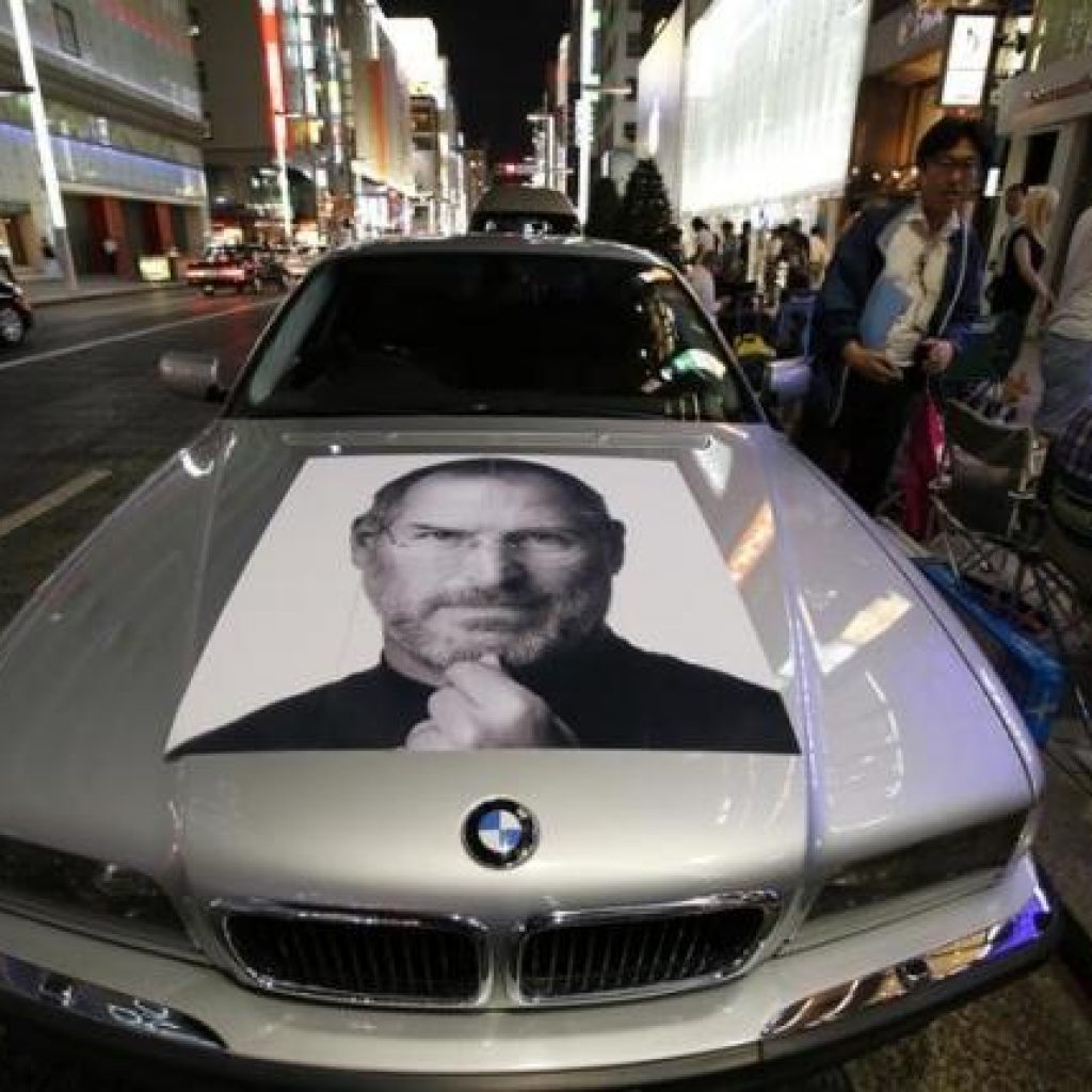 A portrait of Steve Jobs is seen on a BMW as people wait for the release of Apple's new iPhone 5S and 5C in Tokyo